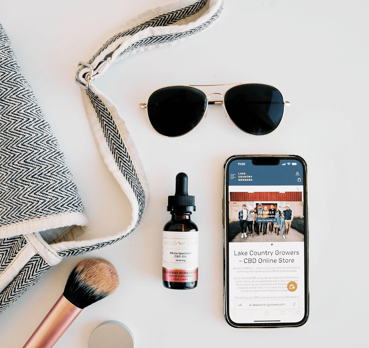 Assortment of travel must-haves including a high-potency CBD tincture alongside a sleek travel bag and fashionable sunglasses, embodying an on-the-move lifestyle with a focus on wellbeing